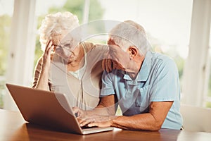 Worried senior couple using laptop