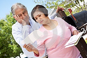 Worried Senior Hispanic Couple Checking Mailbox