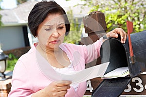 Worried Senior Hispanic Woman Checking Mailbox