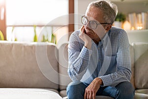 Worried senior man sitting alone in his home