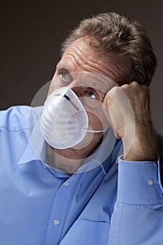 Worried senior man with surgical mask stays at home