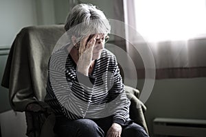 Worried senior woman at home felling very bad