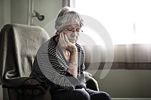 Worried senior woman at home felling very bad
