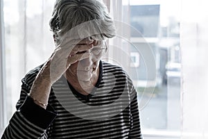 Worried senior woman at home felling very bad