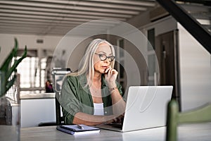 Worried senior woman using laptop