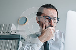 Worried shareholder analyzing stock prices on online market from business office