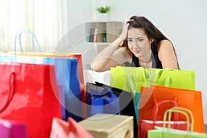 Worried shopaholic woman after multiple purchases photo