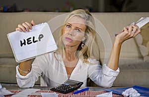 Worried and stressed Caucasian 40s woman holding notepad calculating domestic expenses and taxes payments in budget problem and fi