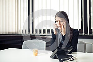 Worried stressed depressed office worker business woman receiving bad news emergency phone call at work.Looking confused