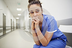 Worried and stressed doctor sitting on corridor