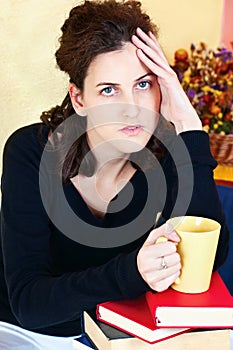 Worried student and bunch of books at home