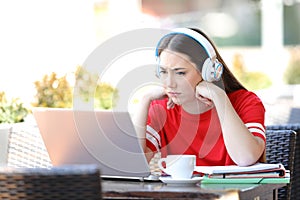 Worried student e-learning watching tutorials on laptop