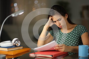 Worried student in the night trying to memorize notes photo