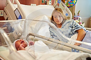 Worried Teenage Girl With Crying Newborn Baby In Hospital