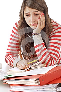 Worried teenage girl with piles of school books