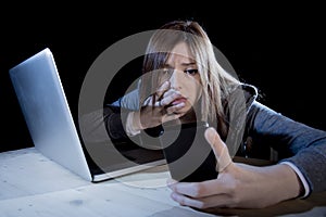 Worried teenager using mobile phone and computer as internet cyber bullying stalked victim abused