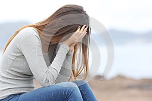 Worried teenager woman on the beach in winter