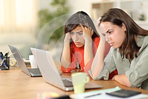 Worried tele workers checking bad news on computer