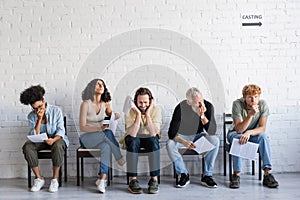 worried and thoughtful multiethnic actors sitting photo