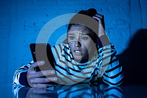 Worried unhappy young woman suffering from cyberbullying and harassment online by mobile phone
