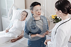 Worried wife talking to doctor about her ill husband