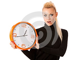 Worried woman with big orange clock gesturing delay, rush, nervous, stress because of lack of time.