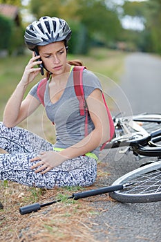 Worried woman calling for help after falling from bicycle