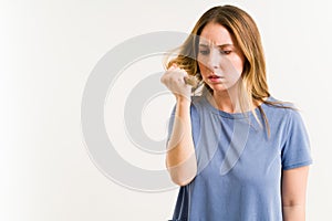 Worried woman checking her unhealthy hair