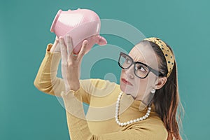 Worried woman checking a money box with her savings