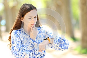 Worried woman checking smartwatch in a park