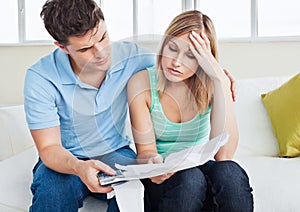 Worried woman looking at bills with her boyfriend