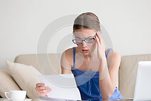 Worried woman reading negative news in letter, failed bad result