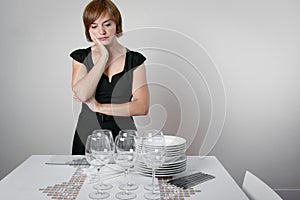 Worried woman setting the table