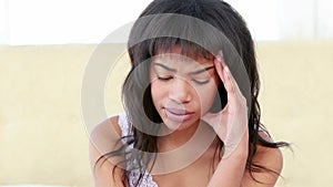 Worried woman sitting on her bed