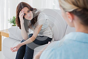 Worried woman sitting and looking at her therapist