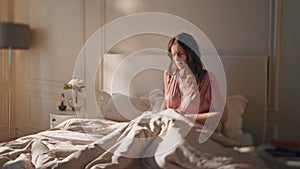 Worried woman suffering stomach ache in morning. Awake sad girl touching belly