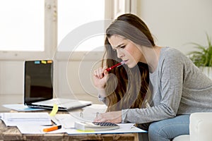 Worried woman suffering stress doing domestic accounting paperwork bills and invoices