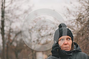 Worried woman talking on mobile phone on street