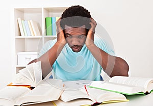 Worried young african man studying photo