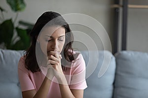 Worried young arabian woman praying god trying to concentrate