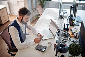 Worried young business man texting on his cell phone. men, modern, office, business, bad news  concept