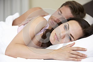 Worried Young Couple In Bed