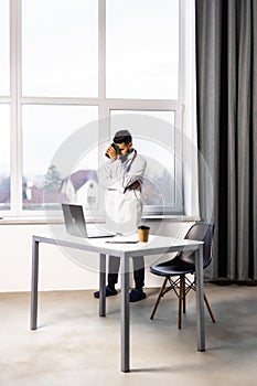 Worried young doctor sitting in his office with hands on his head