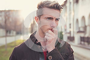 Worried young man biting nails