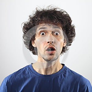 Worried young man with brown eyes and curly hair