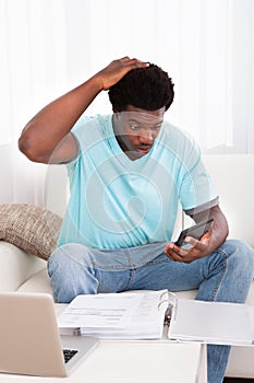 Worried Young Man Holding Calculator