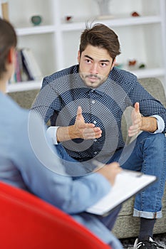 Worried young man on psychotherapy with doctor
