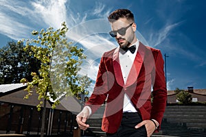 Worried young man wearing red velvet tuxedo