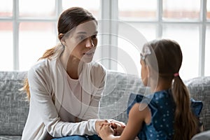 Worried young mommy supporting, giving advice to little daughter.