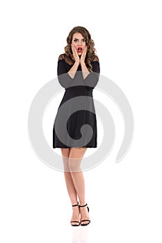 Worried Young Woman In Elegant Black Dress And High Heels Is Holding Head In Hands